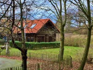 a house with a red roof and a fence at Blockhaus Christoph Columbus - Meerblick in Sassnitz
