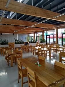 an empty restaurant with wooden tables and chairs at Pivotel MMX in Dobřichovice +32 photos