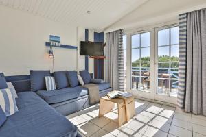 a living room with a blue couch and a tv at Résidence Pierre & Vacances Le Domaine de Bourgenay in Talmont