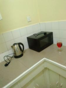 a microwave sitting on a counter with a glass of wine at GG homes in Nairobi