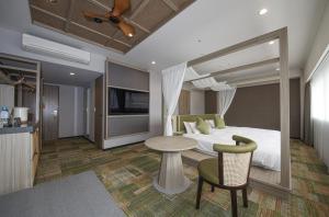 a hotel room with a bed and a table at Spa World HOTEL&RESORT in Osaka