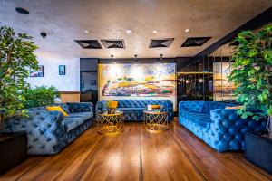a living room with blue couches and a painting at Amsterdam Hotel in Belgrade