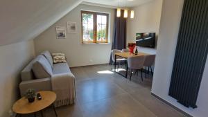 una sala de estar con un sofá y una mesa en Lubie Apartments Lubieszewo, en Lubieszewo