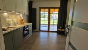 una cocina con fregadero y estufa horno superior en Lubie Apartments Lubieszewo, en Lubieszewo