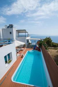 a swimming pool on the deck of a house at White-Blue Luxury Villa 2 in Pefkali