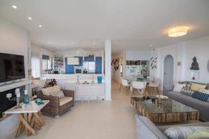 a living room and kitchen with a couch and a table at White-Blue Luxury Villa 2 in Pefkali