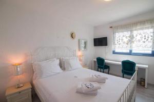 a bedroom with a white bed with two chairs and a desk at White-Blue Luxury Villa 2 in Pefkali +29 photos
