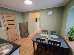 a kitchen and dining room with a table and chairs at Apartament Mała Twierdza in Srebrna Góra