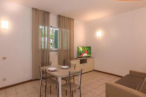 a living room with a table and a tv at Camping Europa in Marina di Massa