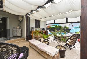 een patio met een bank en stoelen onder een luifel bij Apartments Zeljka 1787 in Vodnjan