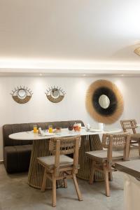 a restaurant with a table and chairs and mirrors at Hotel Villa Flora in Naxos Chora