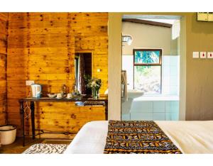 a bedroom with a bed and a bathroom with a sink at Mua Hills Getaway in Katelembu