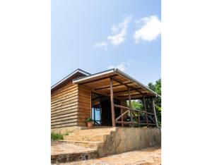 a wooden house with a window and stairs at Mua Hills Getaway in Katelembu +32 photos