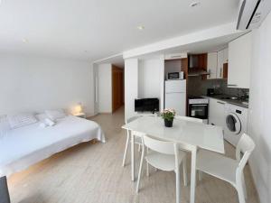 a white room with a bed and a white table and chairs at M2 Apartament cèntric in Terrassa