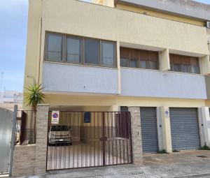 un edificio con un'auto parcheggiata di fronte di Donizetti Vacation Apartment a Porto Cesareo