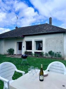 a table with wine glasses on it in a yard at Chez Suzanne in Saint-Père-sur-Loire