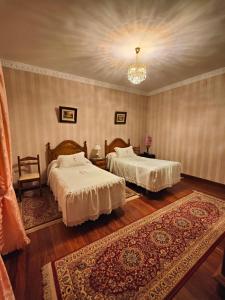 a bedroom with two beds and a chandelier at Pension Lorea in San Sebasti&aacute;n