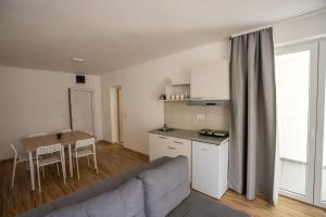 ein Wohnzimmer mit Couch und Tisch und eine Küche in der Unterkunft Milutinn-Visterija in Sokobanja