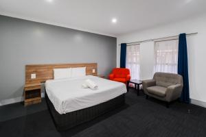 a hotel room with a bed and a chair at Yarra Valley Motel in Lilydale