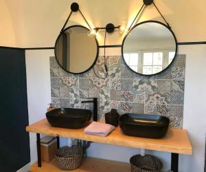 un bagno con lavandino nero e 2 specchi di Villa spacieuse Saint-Hernin avec spa convivial a Saint Hernin Altre 32 foto