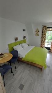 a bedroom with a green bed and a table at Apartmani Terase in Konjska Reka +84 photos