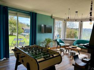 un soggiorno con biliardino al centro di una stanza di Villa spacieuse Saint-Hernin avec spa convivial a Saint Hernin
