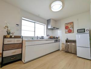 a kitchen with white cabinets and a sink and a window at Tsukiyume Kan - Entire Private House, Free Parking, 10min USJ & Tennoji, Airport Direct Train, Family Group Sleeps 8, 和モダン貸切一軒家 ユニバーサルスタジオ in Osaka