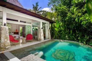 a swimming pool in front of a villa at Umani Village in Kerobokan