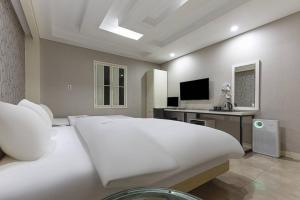 a bedroom with a large white bed and a desk at TJ Hotel in Seoul +16 photos