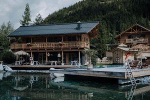 a log cabin with a dock in the water at Bergchalets Gut Wenghof in Werfenweng