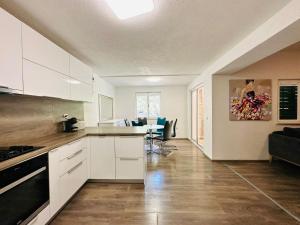 a kitchen with white cabinets and a living room at Beach house Bol in Bol +30 photos