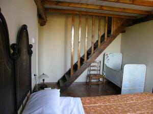 1 dormitorio con escalera, 1 cama y 1 silla en Agriturismo Bosco Del Fracasso, en Scandiano
