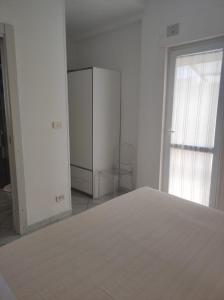 a white room with a refrigerator and a window at Castle on the Sea in Torre Santa Sabina