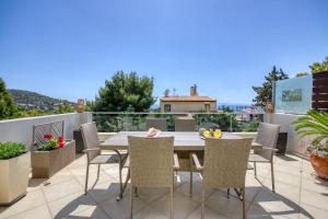 eine Terrasse mit Tisch und Stühlen auf einem Balkon in der Unterkunft Saronida Hills private Pool in Saronida