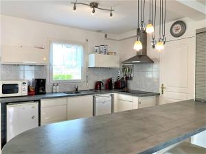 a kitchen with white cabinets and a counter top at Quiberon : maison 6 pers., 3 ch., jardin, quartier calme - FR-1-478-164 in Quiberon