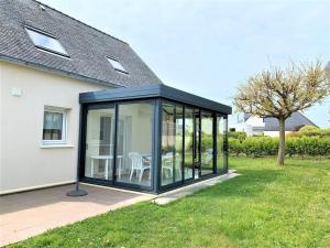a conservatory with a table and chairs in a yard at Quiberon : maison 6 pers., 3 ch., jardin, quartier calme - FR-1-478-164 in Quiberon