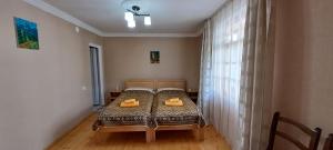 a bedroom with a bed with two yellow shoes on it at Guesthouse Robi in Mestia