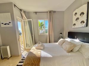 ein Schlafzimmer mit einem großen weißen Bett und einem Fenster in der Unterkunft Sea frontline stylish beach House in Fuengirola