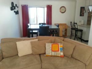 ein Wohnzimmer mit einem braunen Sofa und einem Tisch in der Unterkunft Signature's 21 At the Country Club in Kingston