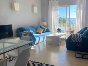 ein Wohnzimmer mit einem blauen Sofa und einem Tisch in der Unterkunft Sea frontline stylish beach House in Fuengirola