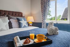 a tray of food and drinks on a bed at Klara in Sandefjord