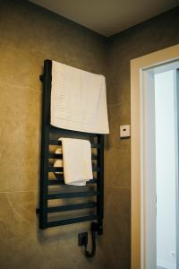 a towel rack in a bathroom with towels at Taikos apartamentai in Klaipėda