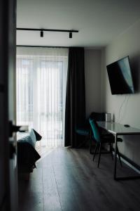 a living room with a desk and a window at Taikos apartamentai in Klaipėda
