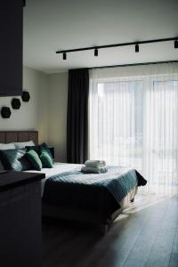 a bedroom with a bed and a large window at Taikos apartamentai in Klaipėda