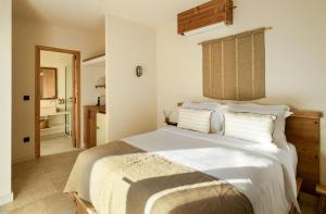 a bedroom with a large white bed with white pillows at Ergon Beach House Nikiti in Nikiti
