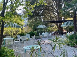 a group of tables and chairs with umbrellas at Haus Marianne in Millstatt +44 photos