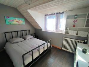 ein Schlafzimmer mit einem Bett und einem Fenster in der Unterkunft Au bonheur des voyageurs in Concarneau