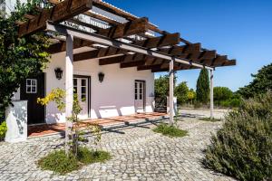 a patio of a house with a wooden pergola at Casas do Chaparral in Grândola