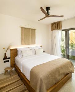 a bedroom with a large bed with a ceiling fan at Ergon Beach House Nikiti in Nikiti