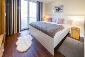 a bedroom with a bed and a large window at Haus Oldenburg - Wohnung 3 mit Balkon in Wangerooge